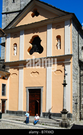 Zwei Männer im Chat vor der Pfarrkirche San Gottardo Intragna, Centovalli, Tessin, Schweiz Stockfoto