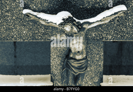 Grabstein mit Christus-Statue in Sepia Schnee bedeckt und blauen Ton Stockfoto