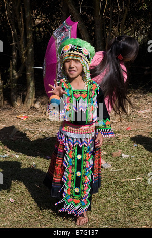 Ein junges Mädchen Hmong, soll in Tracht, einen Ball fangen auf einem Ball werfen Zeremonie am Stadtrand von Phonsavan Stockfoto