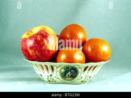 Apfel und Mandarinen auf Tabelle in Porzellan Vase Honig knusprig rot rosa gelb Stillleben Früchte Lebensmittelzusammensetzung angeordnet Stockfoto