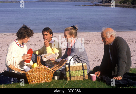 paar mit älteren Eltern mit einem Picknick an einem schottischen Strand Stockfoto