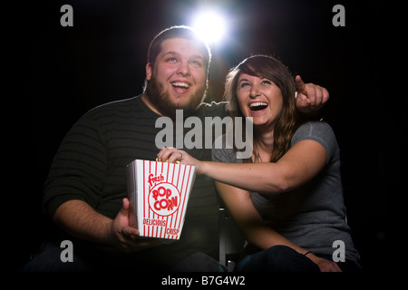 Ein junges Paar im Kino Lachen und Essen popcorn Stockfoto