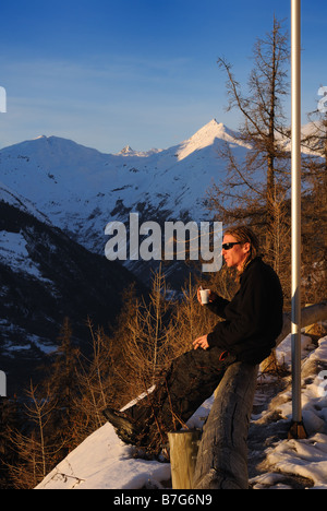 Junger Mann mit einem Tee am Rande der Berghang Stockfoto