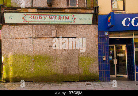 städtischen Verfall Großbritannien geschlossen und sich an Bord Shop neben dem Coral Wetten Shop im Zentrum von Llanelli Carmarthenshire West Wales UK Stockfoto