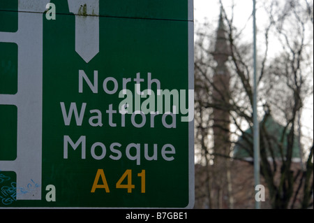 Ein Schild angegeben wo die North Watford-Moschee ist mit der Moschee im Hintergrund Stockfoto