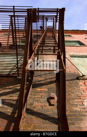 Alten Feuerleiter Nachschlagen von Seite der alten Ziegel Bau, emergency Exit, Fluchtweg Stockfoto