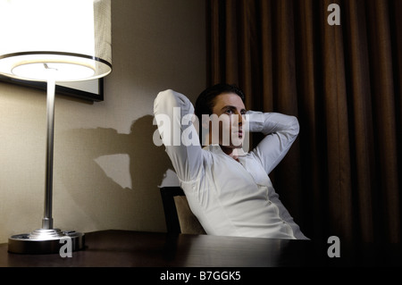 Junger Mann sitzt an einem Schreibtisch Stockfoto