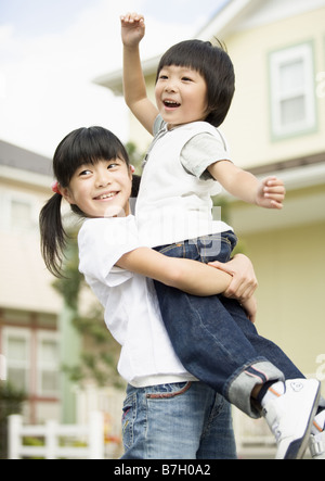 Schwester Bruder anheben Stockfoto