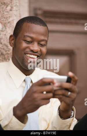 Afrikanischen Geschäftsmann senden SMS Stockfoto