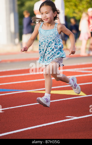 Asiatische Mädchen laufen auf Rennstrecke Stockfoto