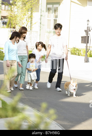 Familie, die ihren Hund spazieren gehen Stockfoto