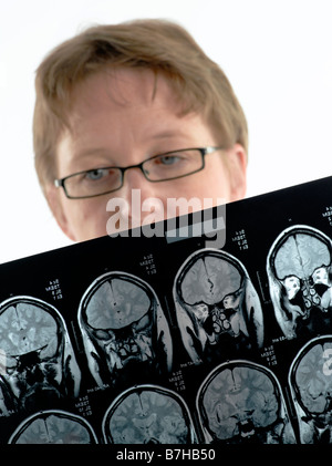 JUNGE ÄRZTIN MIT MRT-UNTERSUCHUNG DES GEHIRNS Stockfoto