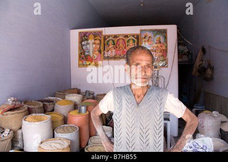 Graue bärtige indischen Mann, stehend mit Händen auf den Hüften im Gewürzgeschäft, Jaipur, Indien Stockfoto
