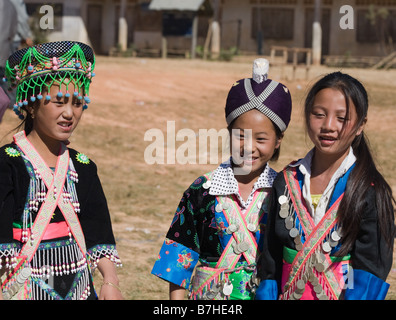 Drei junge Hmong Mädchen in Tracht bei der Hmong Silvester Feier in einer ländlichen Kleinstadt im nördlichen Laos. Stockfoto