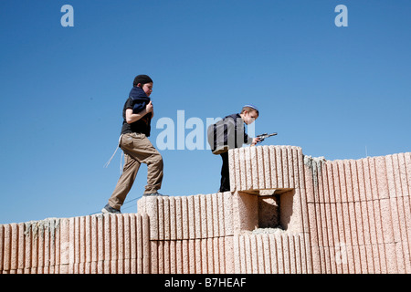 Israelische Siedler Kinder klettern an der Wand beim Purim feiern ein jüdisches religiöses Fest in Hebron im Westjordanland. Stockfoto