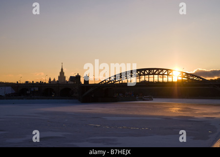 Die Sonne scheint durch Eisenbahnbrücke an einem winterlichen Abend in Moskau Stockfoto