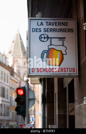 Zeichen der Taverne Schlosserstub im Hintergrund die Kirche L Eglise St. Thomas Stockfoto