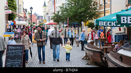 Menschen zu Fuß in die Einkaufsstraße mit Bars auf Bürgersteig Warener Deutschland Stockfoto