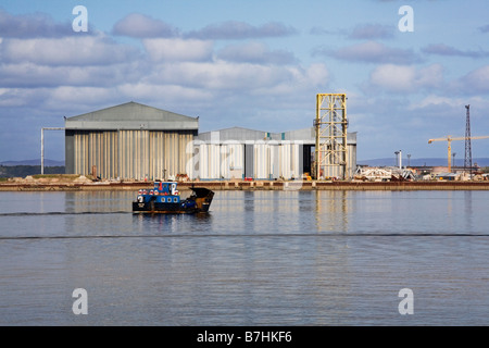 Die Nigg Bay Autofähre überqueren den Cromarty Firth mit der Öl-Rig-Fertigung arbeitet darüber hinaus Stockfoto