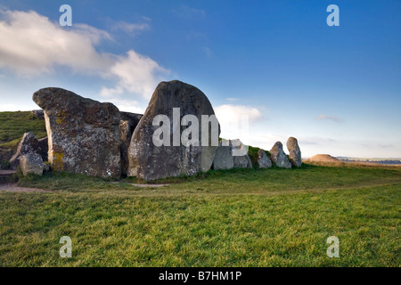 West Kennet Longbarrow mit Silbury Hill im Hintergrund in der Nähe von Avebury, Wiltshire Stockfoto
