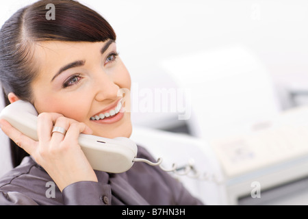 Glücklich Geschäftsfrau Festnetz telefonieren in einem hellen Büro Stockfoto