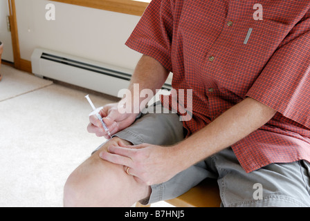 Person, die sich mit einem Medikament injizieren Stockfoto