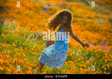 junges Mädchen laufen und spielen in einem Feld von Wildblumen kalifornische Mohn (Eschscholzia Californica) in Lake Elsinore, California Stockfoto