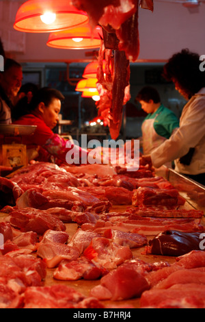 Chinesische Metzger Schneiden von Fleisch im lokalen Markt Stockfoto