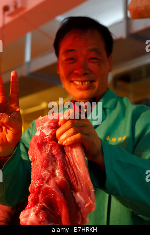 Freundlichen Metzger Unterpfand Fleisch im chinesischen Markt Stockfoto