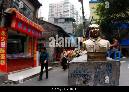 CHinas aufstrebende Wirtschaft Vorsitzender Mao Statue stehen auf Wand mit Werbung für gefälschte Belege und gefälschten Lizenzen während Stockfoto