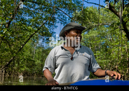 Ein Ngobe Guide führt Touristen auf einem Kanu, einem Mangroven gesäumte Bach in Bahia Honda Isla Bastimentos, Bocas del Toro, Panama Stockfoto