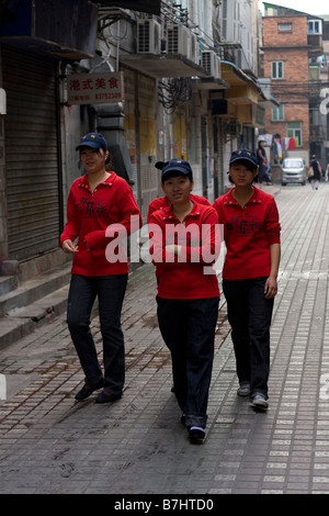 Eine Gruppe von am ehesten chinesischer Wanderarbeiter junge Gladies Weg zur Arbeit, es ist oft, dass 4 6 Mitarbeiter teilt ein kleines Roo Stockfoto