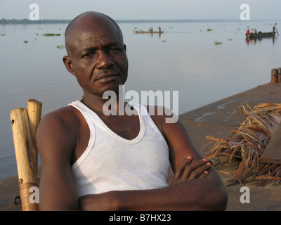 Porträt von schwarzen afrikanischen Mann in weißer Weste entspannen im Liegestuhl auf Kahn im Fluss Kongo Demokratische Republik Kongo Stockfoto