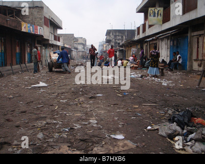 Abfall und Müll gefüllte Straße in Kinshasa Kongo mit Geschäften und Gebäuden heruntergekommen Stockfoto