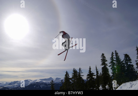 Skifahrer, die einen Sprung in der Sonne mit Skiern überquerte, Courtenay, b.c. Stockfoto