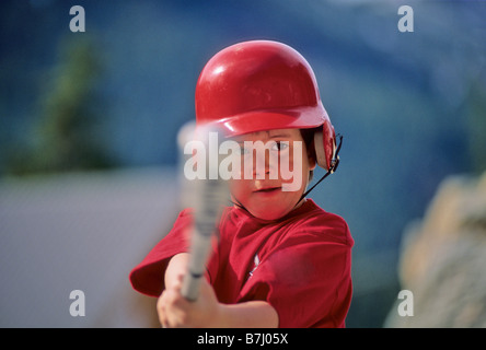 Junge, 6, trifft Baseball bat Stockfoto