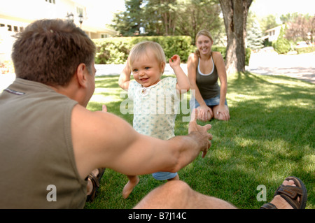 Junger Mann & Frau Lehre Baby zu Fuß in Rasen, Regina, Saskatchewan Stockfoto