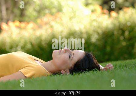 Junge Frau, die Verlegung auf dem Rasen, Regina, Saskatchewan Stockfoto