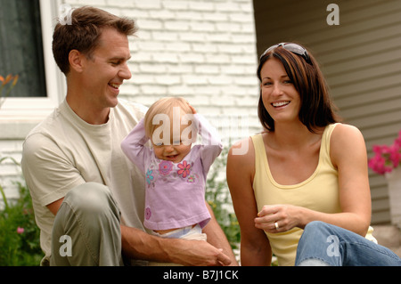 Junges Paar w/Baby vor Haus, Regina, Saskatchewan Stockfoto