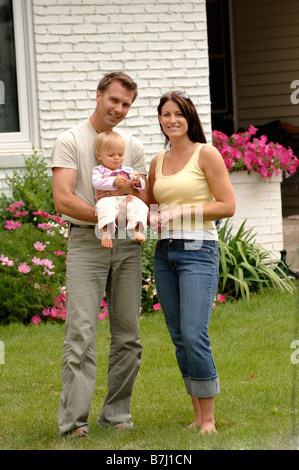 Junges Paar w/Baby vor Haus, Regina, Saskatchewan Stockfoto