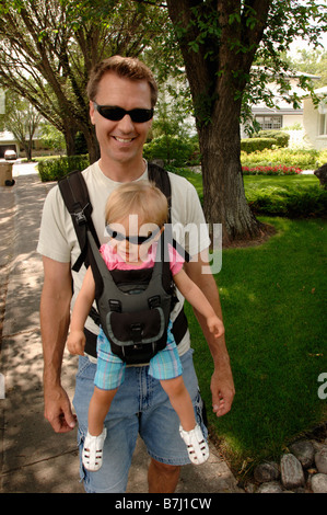 Mann zu Fuß hinunter Straße Tragetasche Baby in kuscheligen, Regina, Saskatchewan Stockfoto