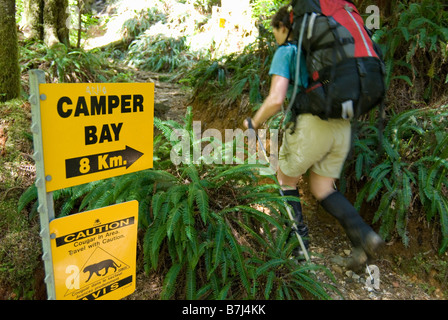 Frau (20-25) mit einem Rucksack auf Wanderland Altwachstum Westküste Regenwald, Pacific Rim National Park Reserve, BC, Kanada Stockfoto