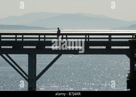 Silhouette eines Mannes zu Fuß entlang einem Pier, Sidney, BC, Kanada Stockfoto