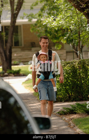 Mann zu Fuß hinunter Straße Tragetasche Baby in kuscheligen, Regina, Saskatchewan Stockfoto