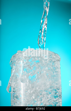 Wasser in überquellenden Glas gießen Stockfoto