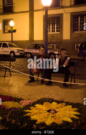 dh Blumenfest FUNCHAL MADEIRA Wandteppich Blume bei Nacht Dekoration Stadt Centre Street und Musiker Stockfoto