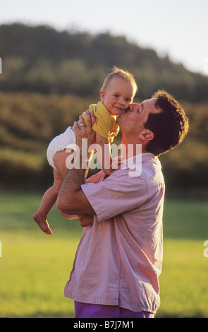 Papa küssen Babymädchen auf die Wange, sie lächelt, Kelowna, BC Stockfoto