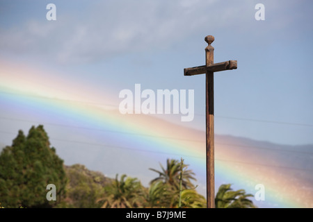 Ein schöner Regenbogen und ein christliches Kreuz. Stockfoto