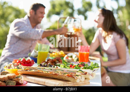 Paar, Essen im Freien, einander Toasten Stockfoto