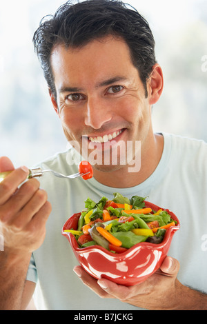 Mitte erwachsener Mann essen Salat Stockfoto